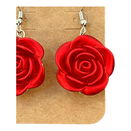 Red rose-shaped earrings on a JenDore brown card