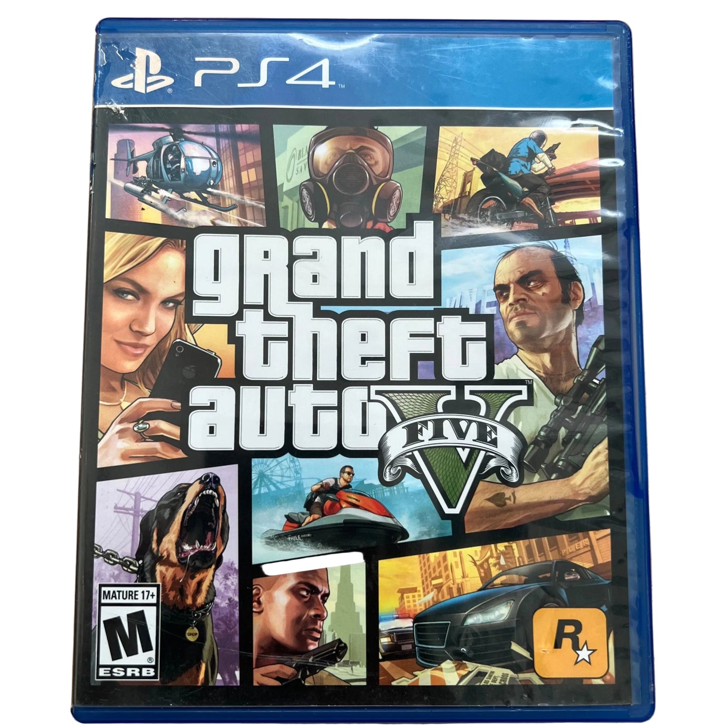 PS4 game case for Grand Theft Auto V on a light wood surface. The blue plastic case shows the game cover art with the PlayStation 4 branding at the top and the Rockstar logo at the bottom right.