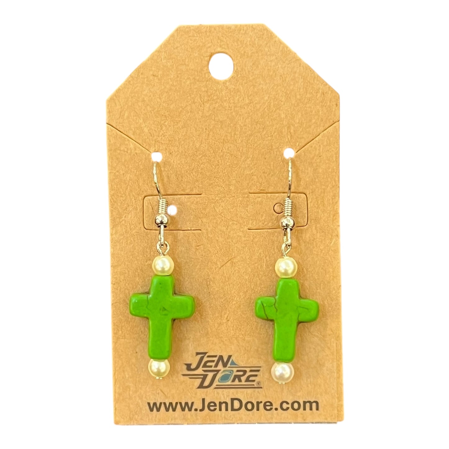 Green cross-shaped earrings with pearl-like beads on a JenDore branded card.