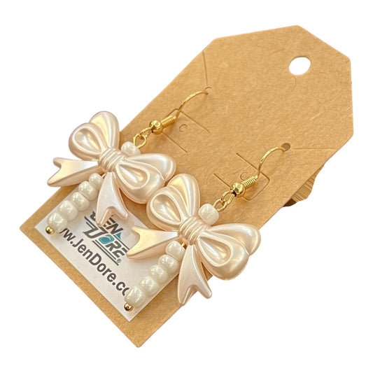 Bow-shaped earrings with pearl details on a JenDore branded card