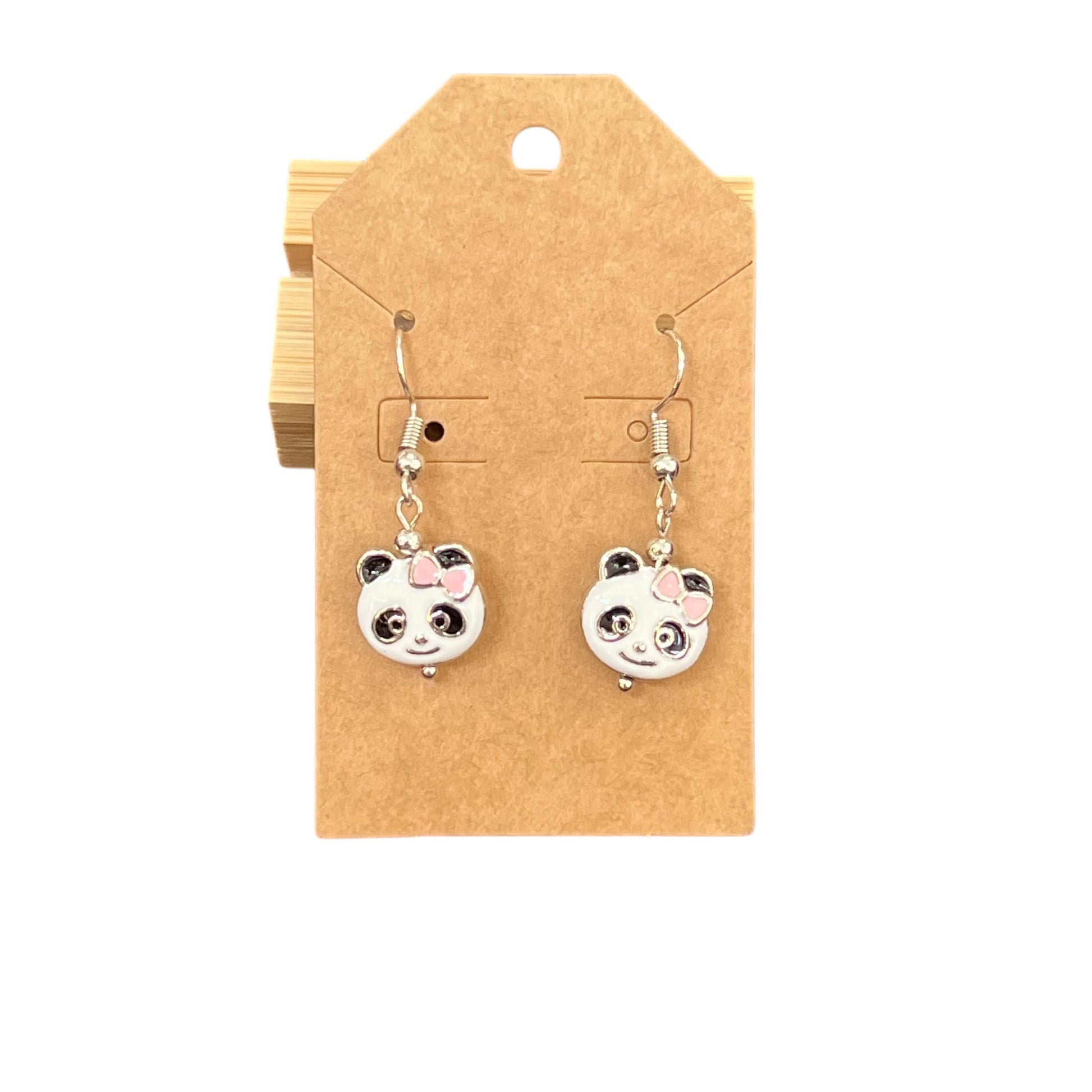 Close-up of JenDore handmade metal panda dangle earrings with pink bow detail and playful, lightweight design.