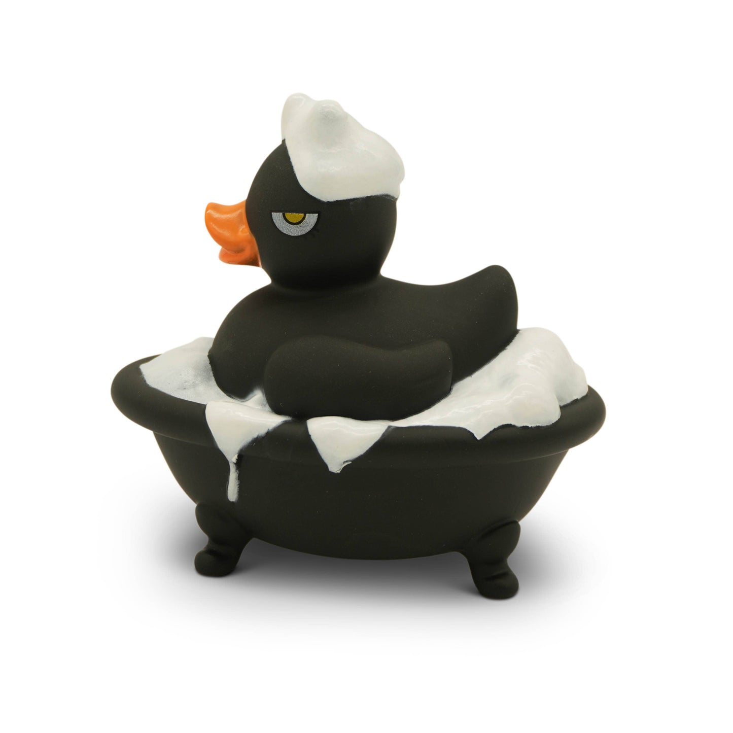 Black rubber duck with a white hat sitting in a bathtub filled with bubbles on a white background